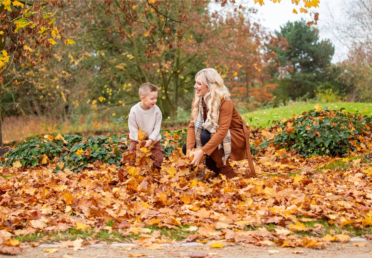 Herbst - Kind und Mutter spielen im Laub